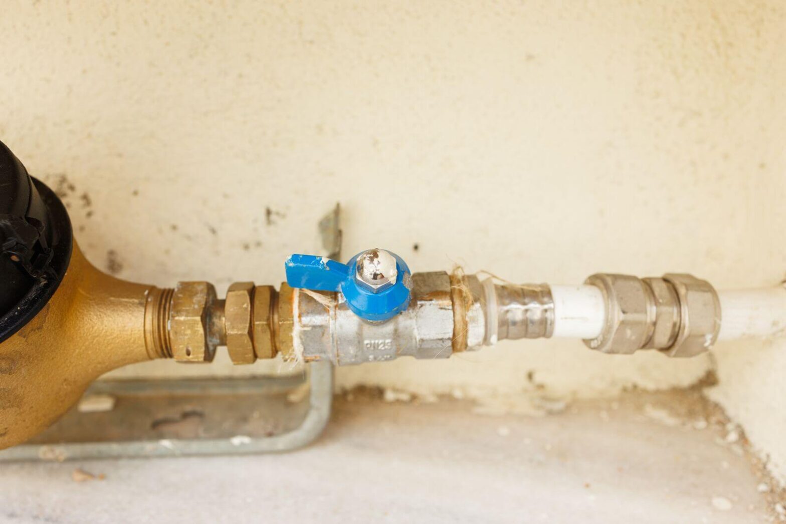 Blue-handled main water shutoff valve connected to a home water line